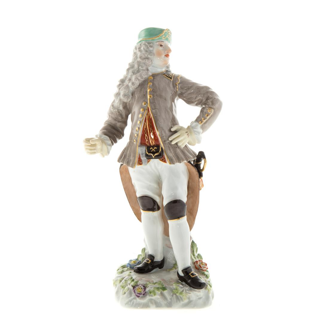 Meissen Porcelain Figure: circa 1924; underglaze blue crossed swords mark, incised/impressed "1336/136," modeled as a military figure, his cap with Augustas Rex monogram, 8 1/4 in. H.Estate of Leo and Martha Leckar. Acquired i