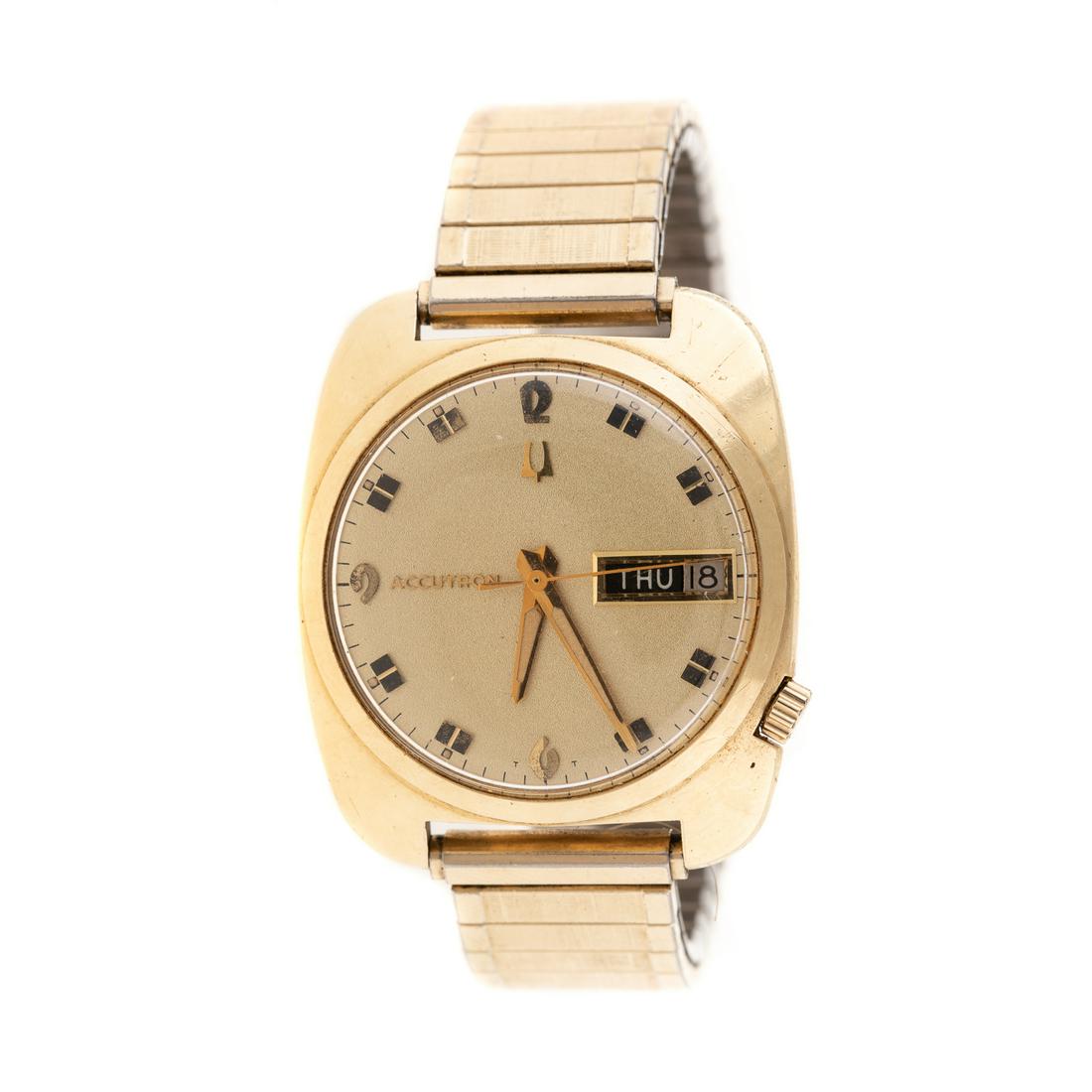 A Gentlemen's Accutron Watch in 14K Gold: 14K yellow gold watch Bulova case serial #F49398 gold Accutron dial with day/date window, on a stretchy Speidel watch band, 70 grams total weight