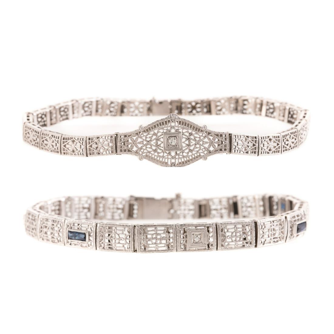 A Pair of Art Deco Filigree & Diamond Bracelets: 1) 14K white gold Art Deco filigree bracelet with four French-cut sapphires and one round diamond in milgrain box setting, concealed box clasp with safety chain, 6.5 in. L, and 2) 14K white gold Art D