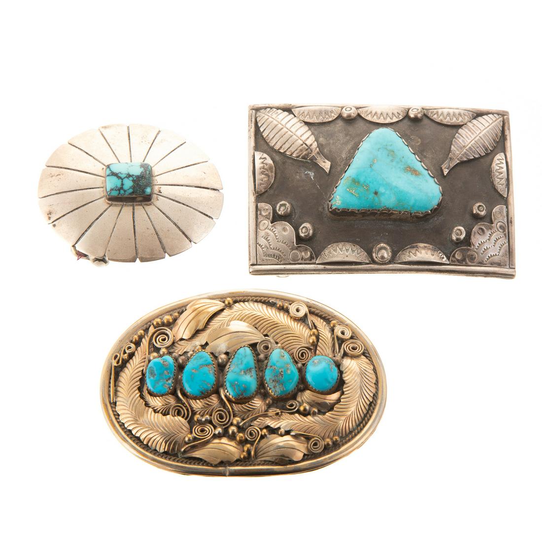 A Trio of Starling Turquoise Belt Buckles: 1) sterling Navajo rectangular belt buckle with leaf design and large triangle shape turquoise in the center, 4 in. L., 2) sterling Navajo oval belt buckle with leaf design and 5 turquoise set in the 