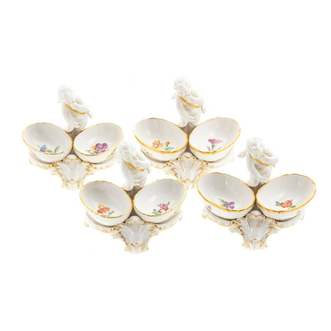 Four KPM Porcelain Figural Salts: Early 20th century; putto with pair oval floral painted bowls on scroll base, gilt accents, 4 in. H., 4 1/2 in. W.