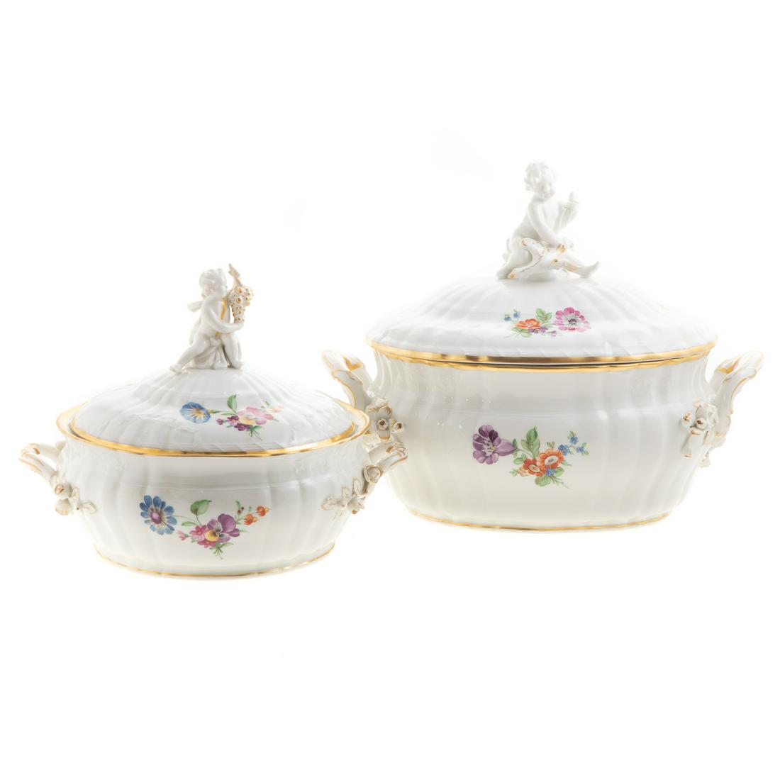 Two KPM Porcelain Covered Serving Dishes: Early 20th century; painted floral decoration, with putto knop, oval shape, 10 in. H., 13 in. L. and circular, 8 in. H., 10 in. Diam.