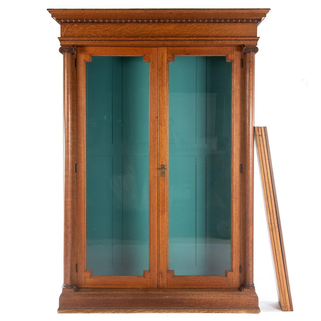 American Classical Style Oak Bookcase: With molded edge cornice, two large glazed panel doors, with column supports, with turquoise painted interior, fitted with interior lights and adjustable shelves. 90 in. H., 63 in. W., 18 in. D.