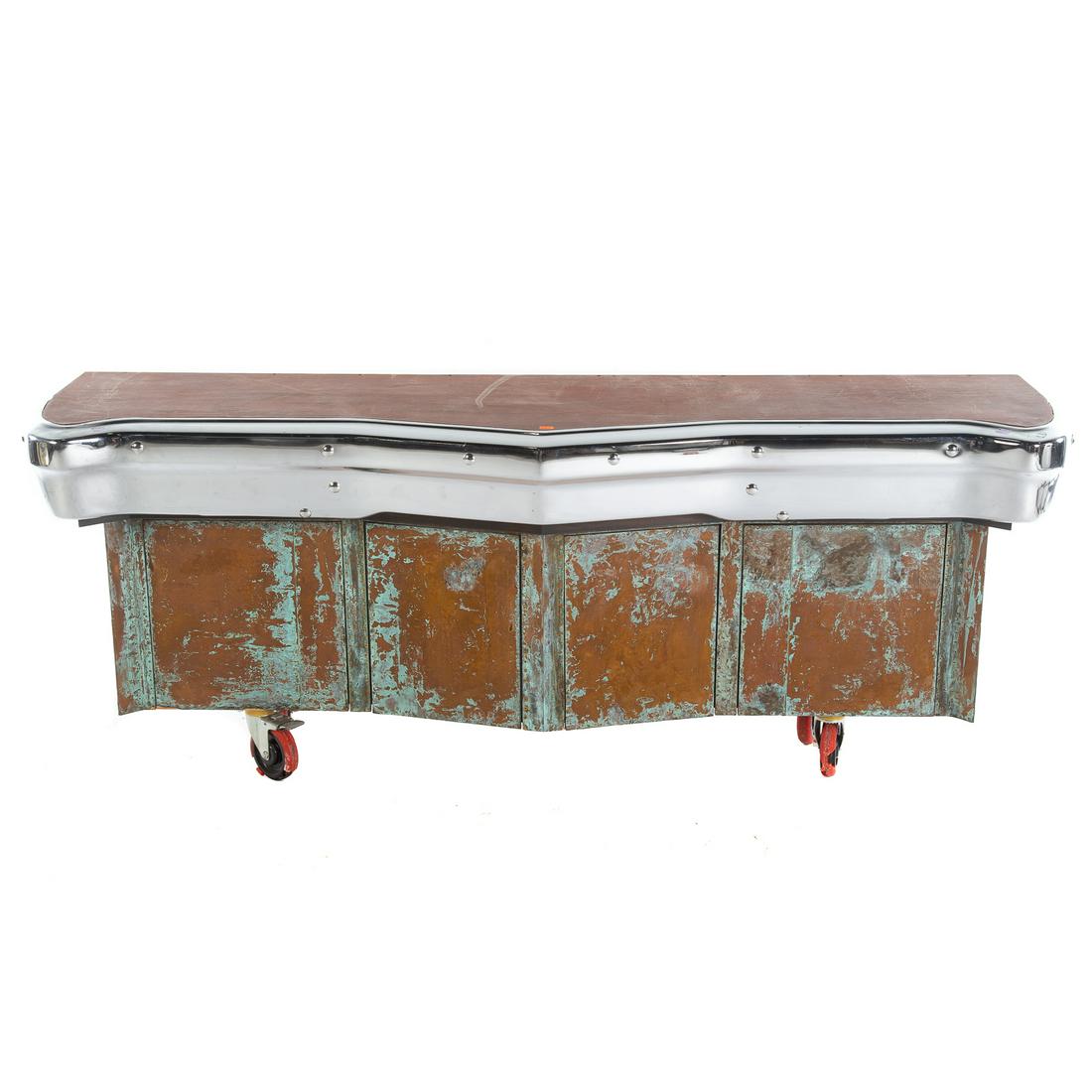 Unusual Console Table From Early Model Cadillac: Chrome Cadillac bumper attached to distressed shaped wood frame, with storage doors, on wheels. 30.5 in. H., 78 in. W., 21 in. D.
