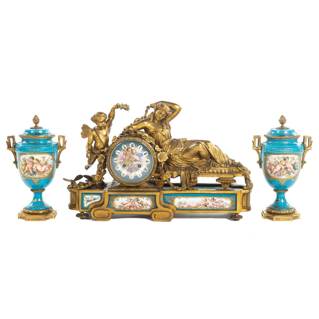 Napoleon III Bronze Figural Clock Garniture: Circa 1860: impressive gilt bronze cased mantel clock , with figures of Venus and Cupid, having inset painted Bleu Celeste panels and clock face depicting putti, probably Sevres, 13 in. H., 20 in. W.,
