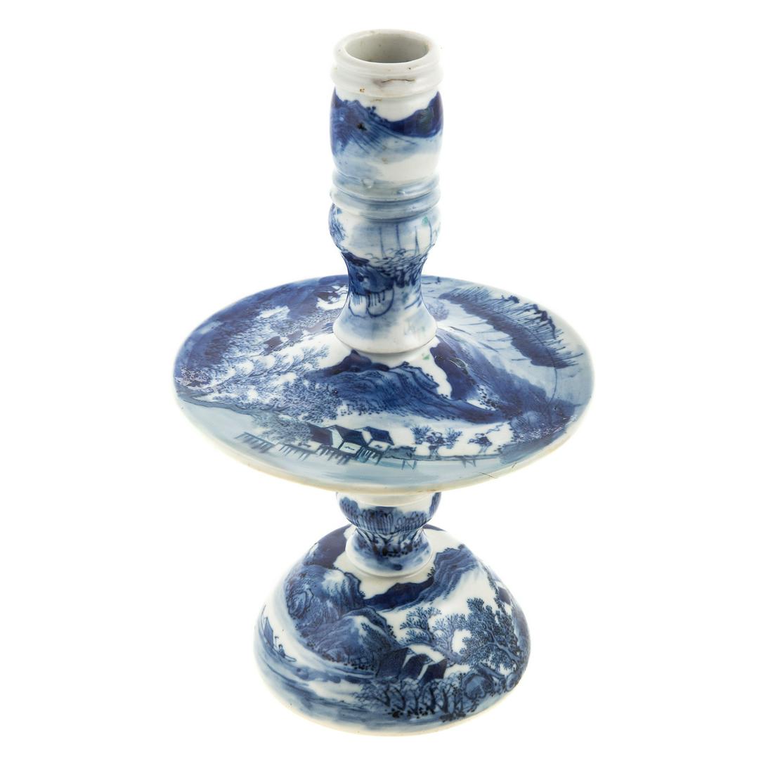 Chinese Export Blue/White Candlestick: 19th century; modeled after Dutch Heemskerk candlestick, with river scene decoration, 10 in. H., 6 in. Diam. of drip pan. Purchased from Philip S. Dubey.