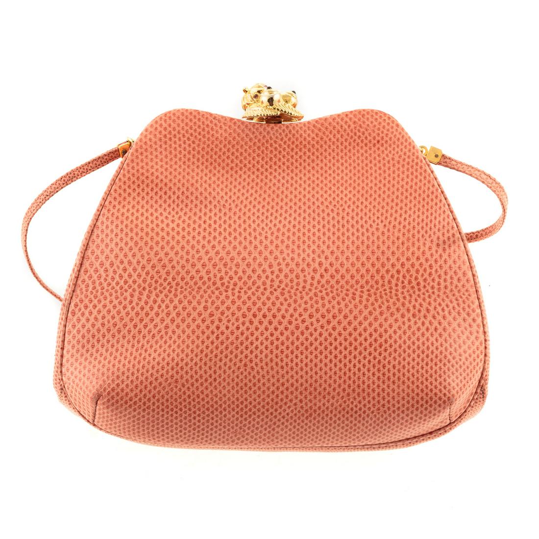 A Judith Leiber Coral Leather Clutch: Coral leather Judith Leiber clutch with gold-tone hardware, single leather shoulder strap, coral satin lining with single slot pocket and embellished strawberry push-lock closure at top. Includes dust
