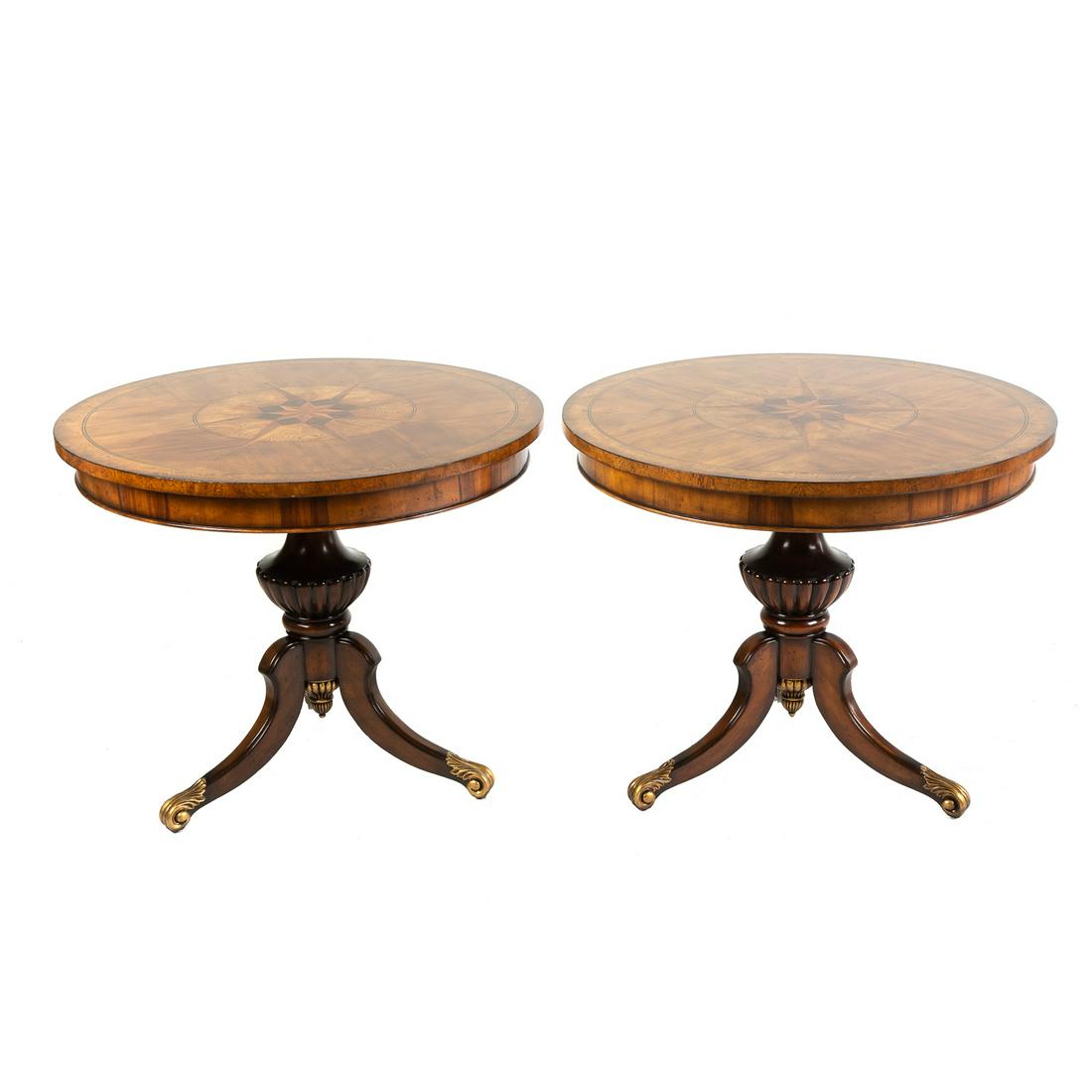 Pair of Century Monarch Explorers Lamp Tables: A pair of round pedestal end tables, with inlaid compass star decorations, stringer inlay, on three- legged urn pedestal base, on gilt scroll feet. 30.5 in H., 36 in. Diam.