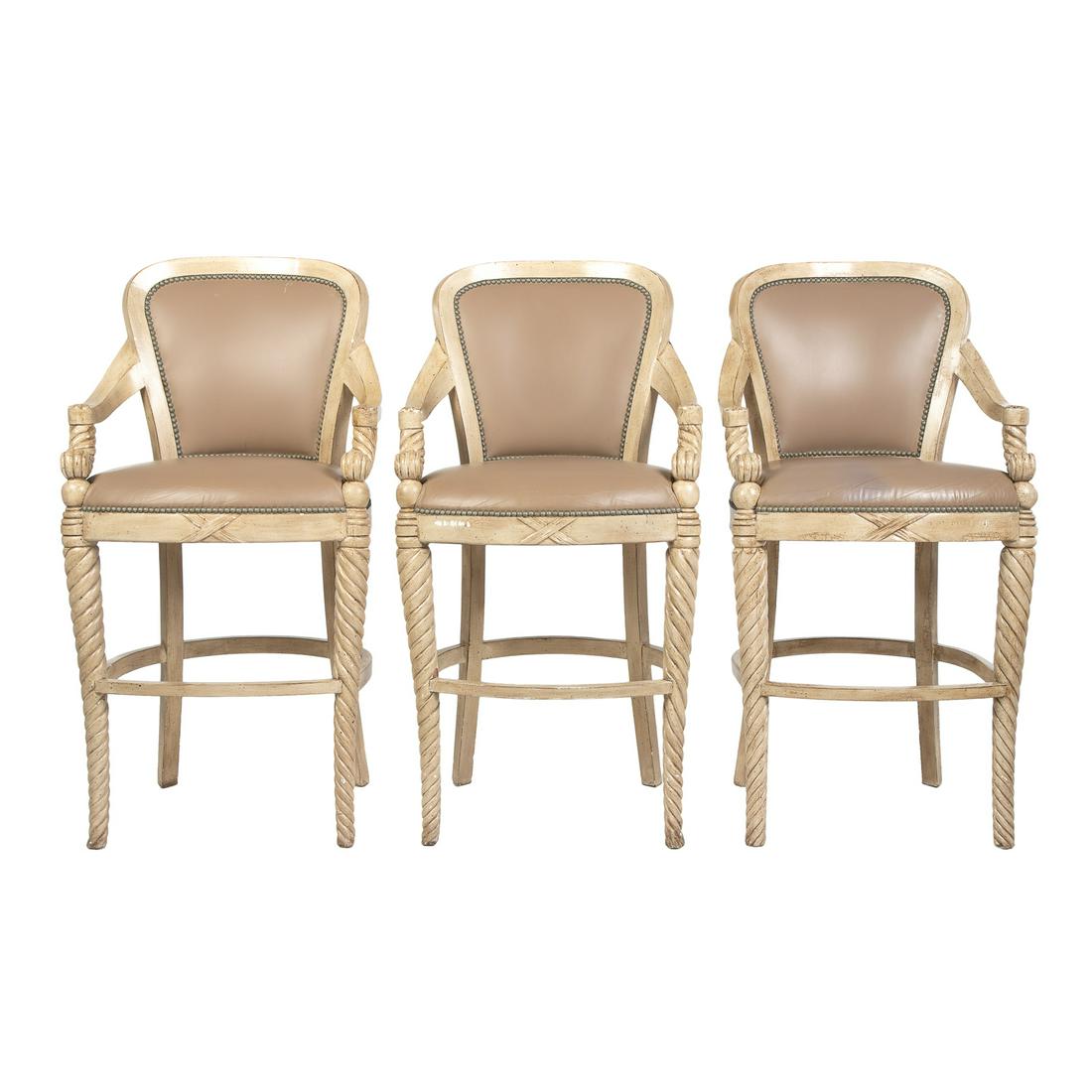 Three Contemporary Painted Counter Stools: Painted wood frames with twist arm supports and front legs, with metal tack and leather upholstery. 48 in. H., 24 in. W., 24 in. D.