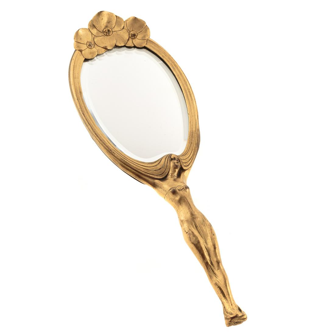 French Art Nouveau Gilt Bronze Hand Mirror: Circa 1900; handle in form of sensuous woman whose hair forms frame with three flowers at top, signed "Karl Bergline," with stamped Paris mark, beveled mirrored glass, 13 1/2 in. L., 4 1/2 in. W.