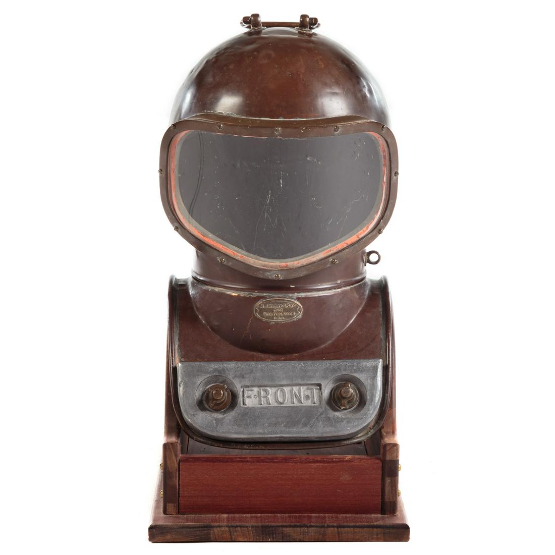 A.J Morse & Son Shallow Water Diving Helmet: Early 20th century; copper helmet with brass and glass visor, with screw on breast and back lid weights, having title plaque. Serial number 157 36906. 23 in. H., 12.5 in. W. with custom made wood disp