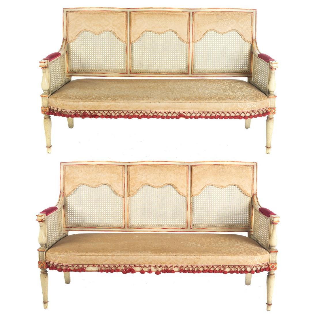 Pair Regency Style Painted / Caned Seat Settee: Upholstered seats with caned backs and sides. 33 in. H., 55 in. W., 17 in. D.