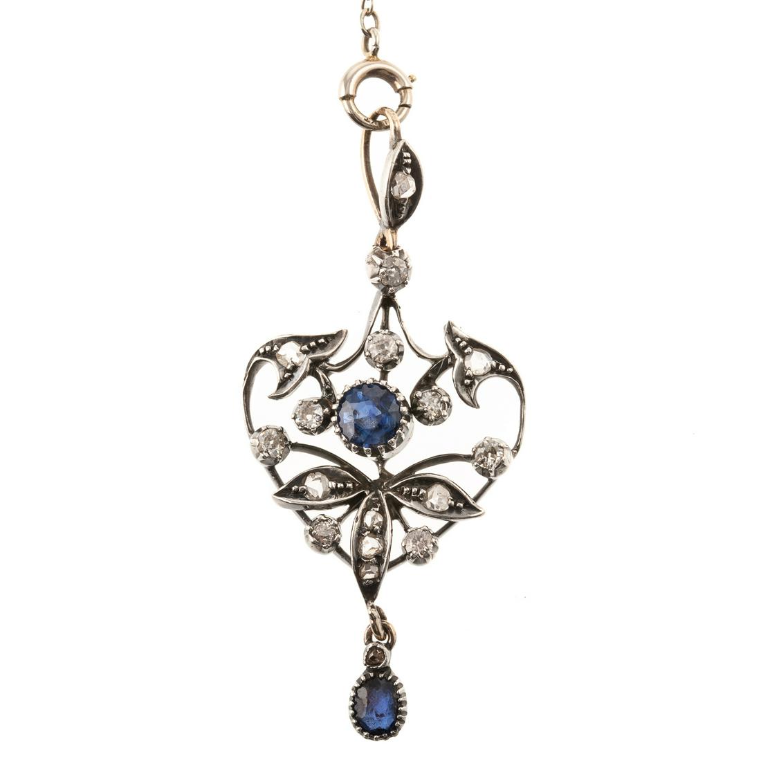 An Edwardian Sapphire & Diamond Pendant in 14K: 14K white gold Edwardian lavaliere pendant featuring a central round cut sapphire and oval sapphire drop in a milgrain setting, eight round cut diamonds, and six rose cut diamonds set with granulation