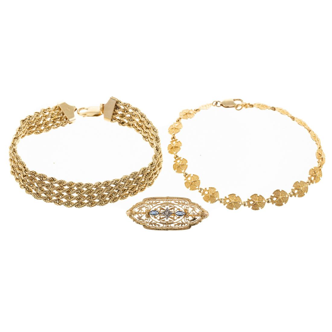 Two Link Bracelets with Filigree Pin in 10K: 1) 10K yellow gold 4 row rope chain with large lobster clasp, 7.5 in. L, 2) 10K yellow gold sand dollar link bracelet with lobster clasp, 7.5 in. L, and 3) 10K yellow gold filigree pin with marquise c