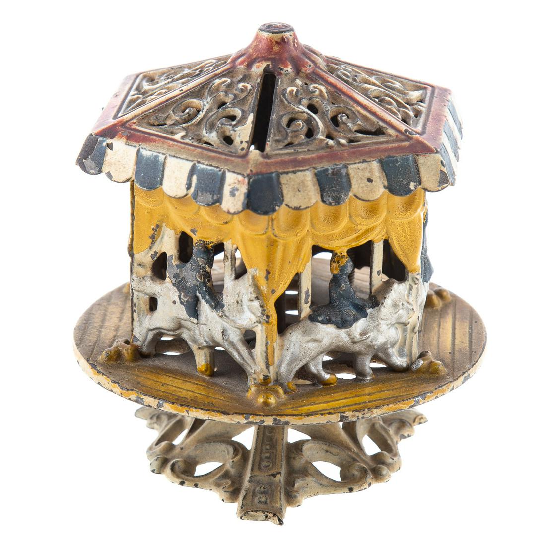 Merry Go Round Cast Iron Bank: Early 20th century; by Grey Iron, with revolving top. 4 1/2 in. H., 4 1/4 in. Diam.