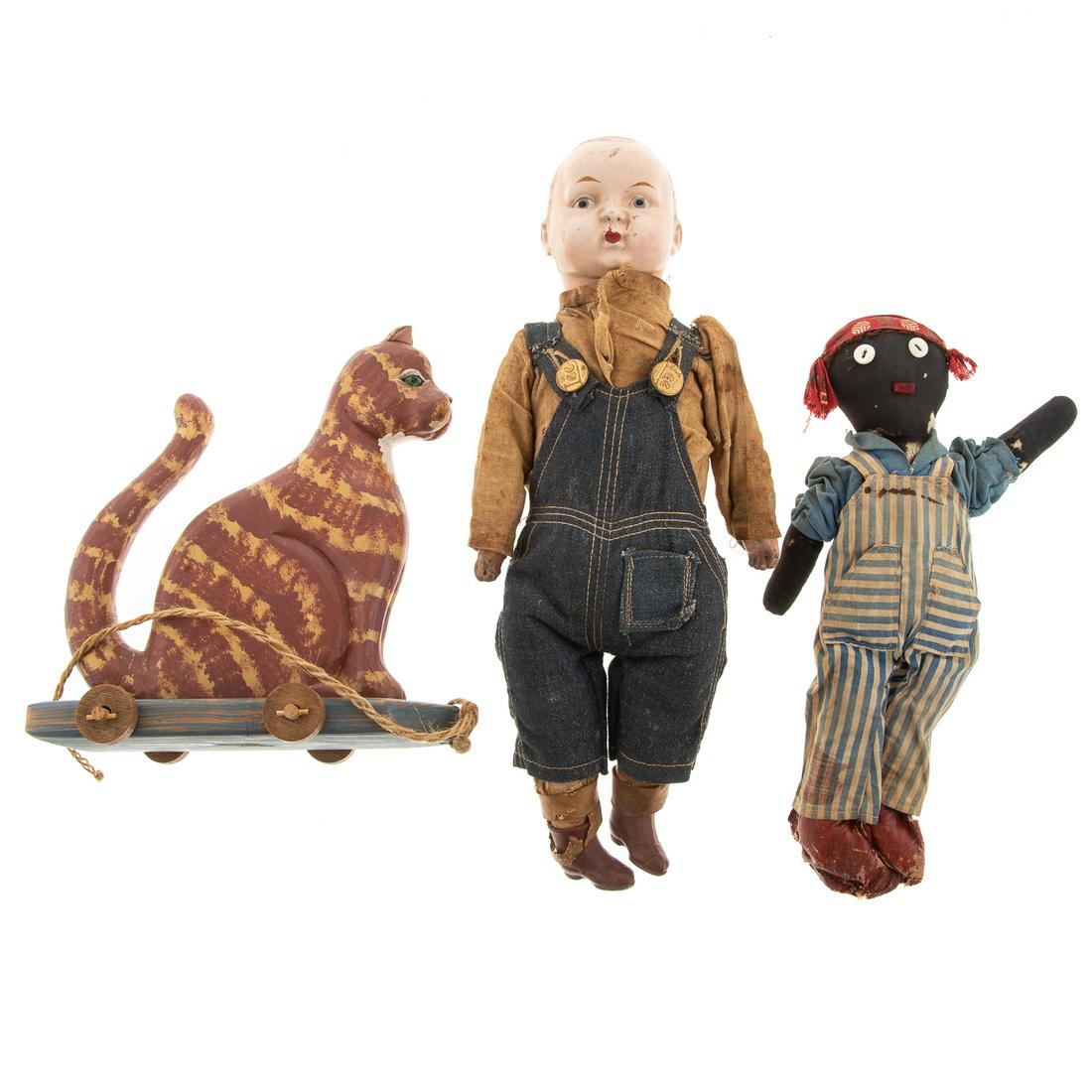 Two Dolls & Cat Pull Toy: Includes; composition and cloth bodied Buddy Lee doll in Lee denim overalls, 15 in. H., primitive black rag doll, 11 in. H., and a antique style painted wood cat pull toy by Robert Kauffman
