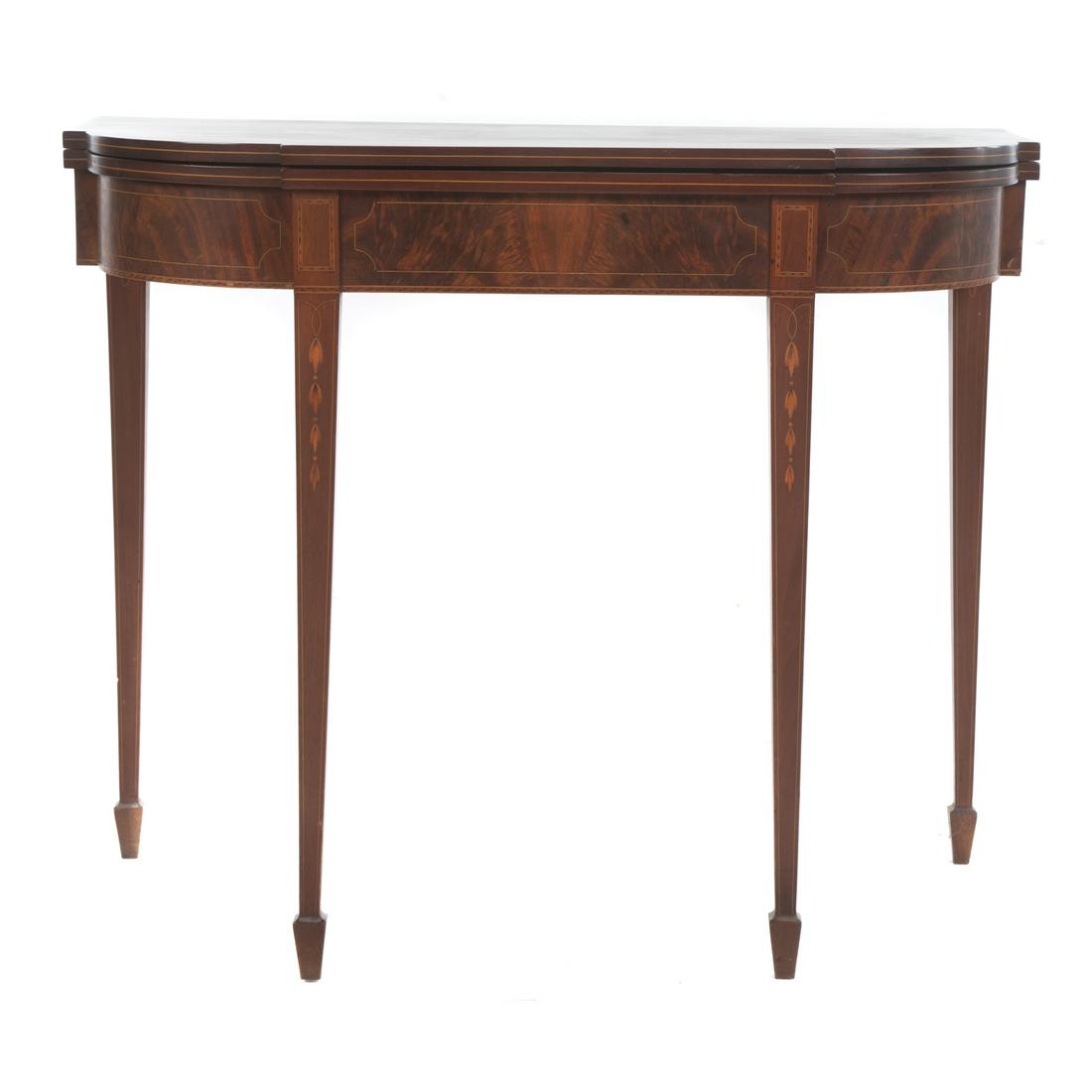 Federal Style Mahogany Inlaid Games Table: Probably Centennial, shaped top with bellflower, stringer, and dash inlays, on square tapered legs, ending in spade feet. 30 in. H., 36 in. W., 18 in. D.