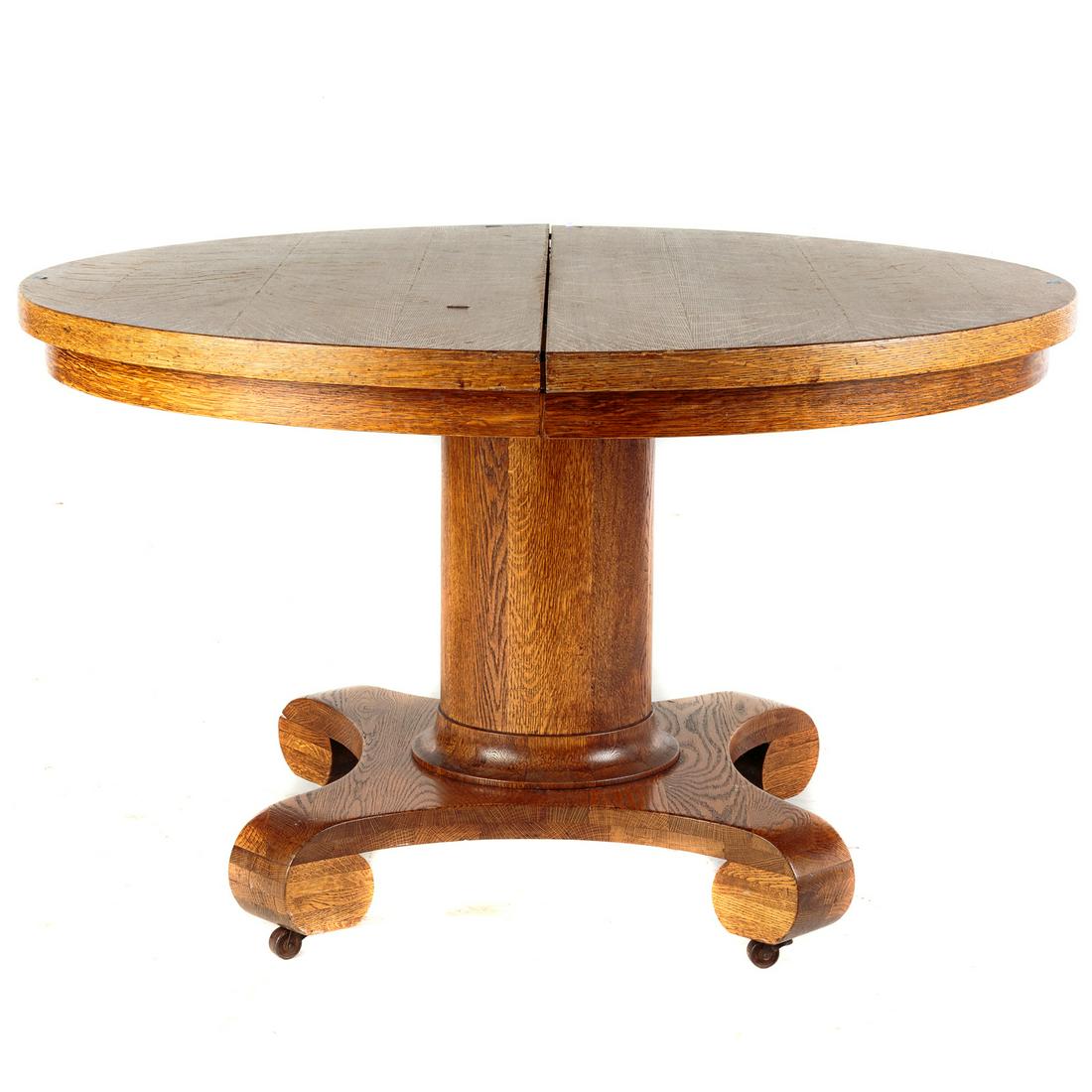 Empire Style Round Oak Pedestal Dining Table: 30 in. H., 48 in. Diam. with five 9 in. extension leaves.