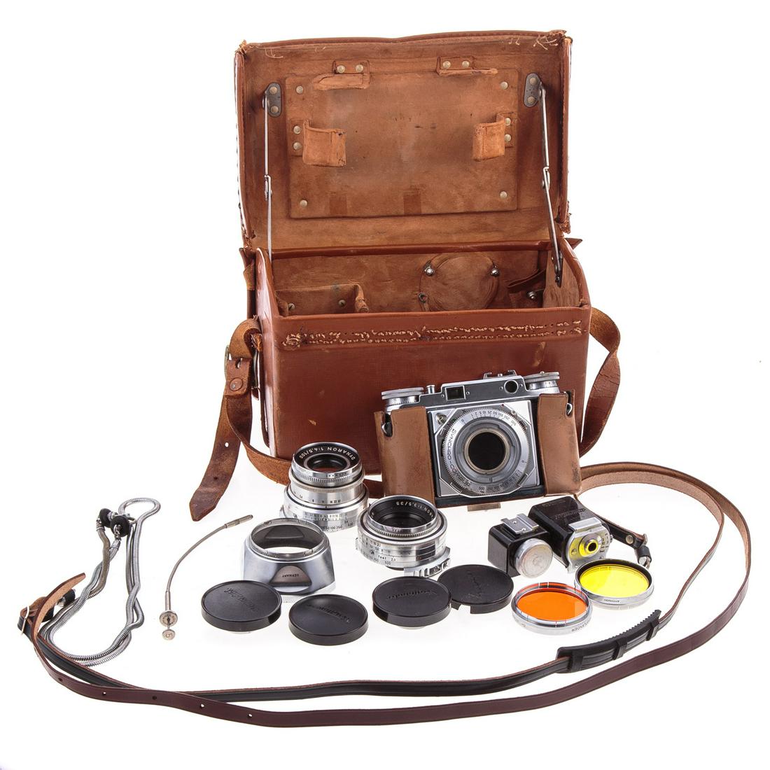 Voightlander Prominent Camera Outfit: Circa 1950s: includes, Voightlander Dynaron 1:4.5/100 lense, Skoparon 1:3.5/35 lense, along with with filters and other attachments in leather carrying case.