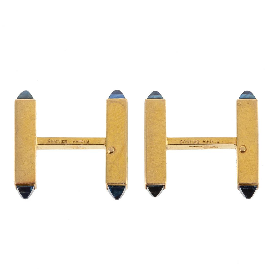 A Pair of Cartier 18K Sugarloaf Sapphire Cufflinks: 18K yellow gold cufflinks by Cartier, Paris, French hallmarks, sugarloaf cut sapphires set in end of swivel bar cufflinks, 0.75 in. L, 8.47 grams tw