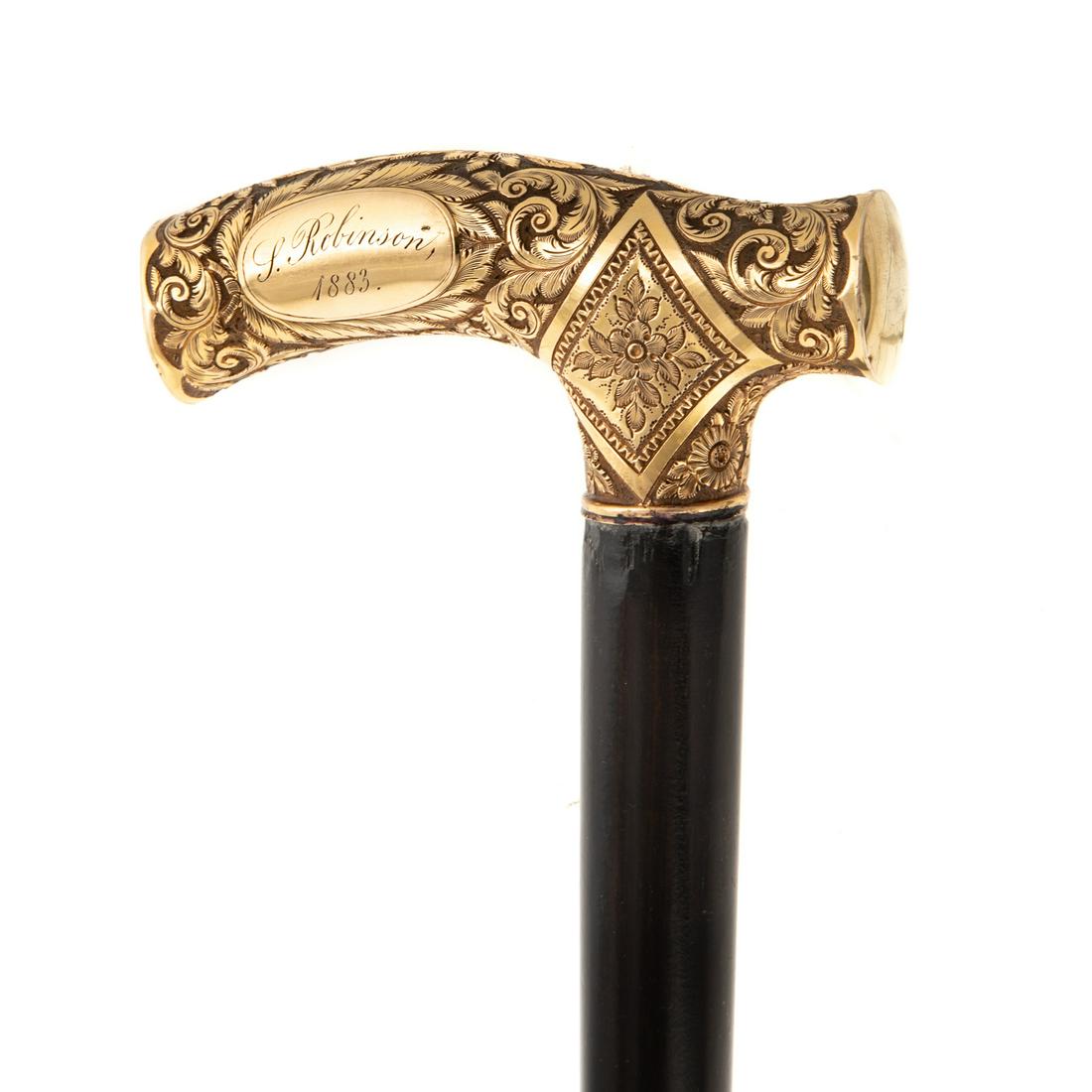 Victorian 14k Gold-Mounted Walking Stick: 14K gold handle, ornately decorated with scrolling foliage and floral reserves, inscribed "P. Robinson 1883," 35 3/4 in. H, handle is 4 in. L Estate of Linda McRae Noe Laine, heiress and philanthropis