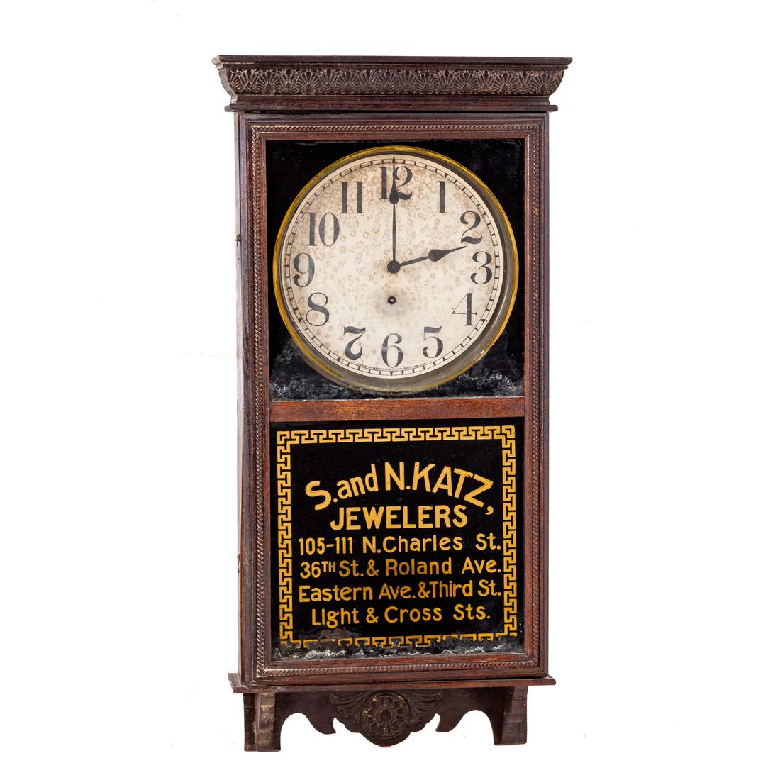 S and N Katz Advertising Wall Clock: Early 20th century; wall regulator, having gilt eglomise panel, reads "S and N Katz Jewelers .....", with Greek Key trim, paper face label, 36 in. H., 18 in. W.