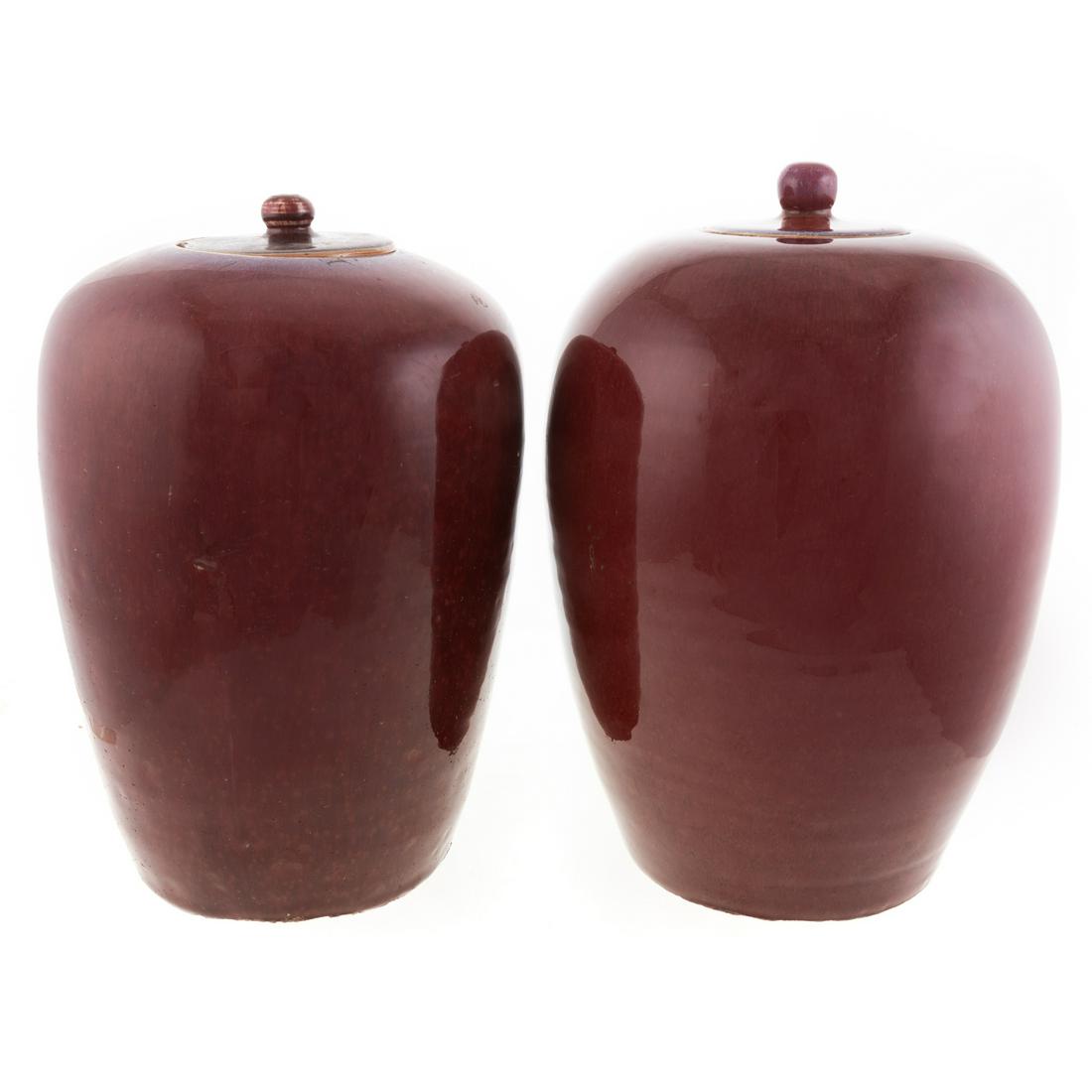 Two Chinese Sang de Boeuf Porcelain Jars: 19th century or earlier; each with flambe accents in lid and around rim, 12 1/2 and 13 in. H. From the Estate of Philip S. Dubey.