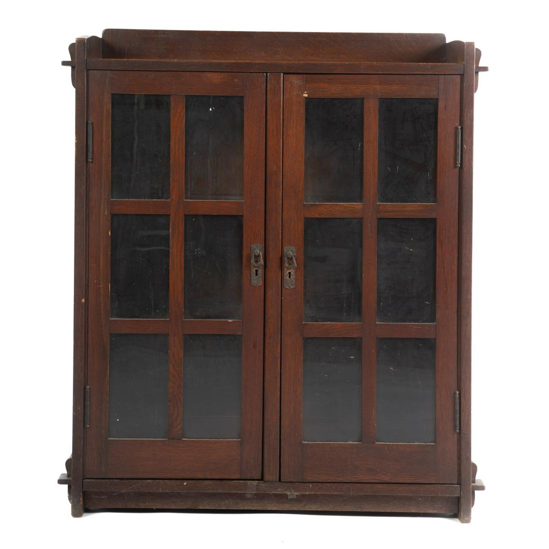Stickley Style Oak Arts & Crafts Mission Bookcase #523: Late 19th/early 20th century; bookcase #523, oak two door cabinet with interior shelving, unknown paper label on back . 45 in. H., 40 in. W., 12 in. D.