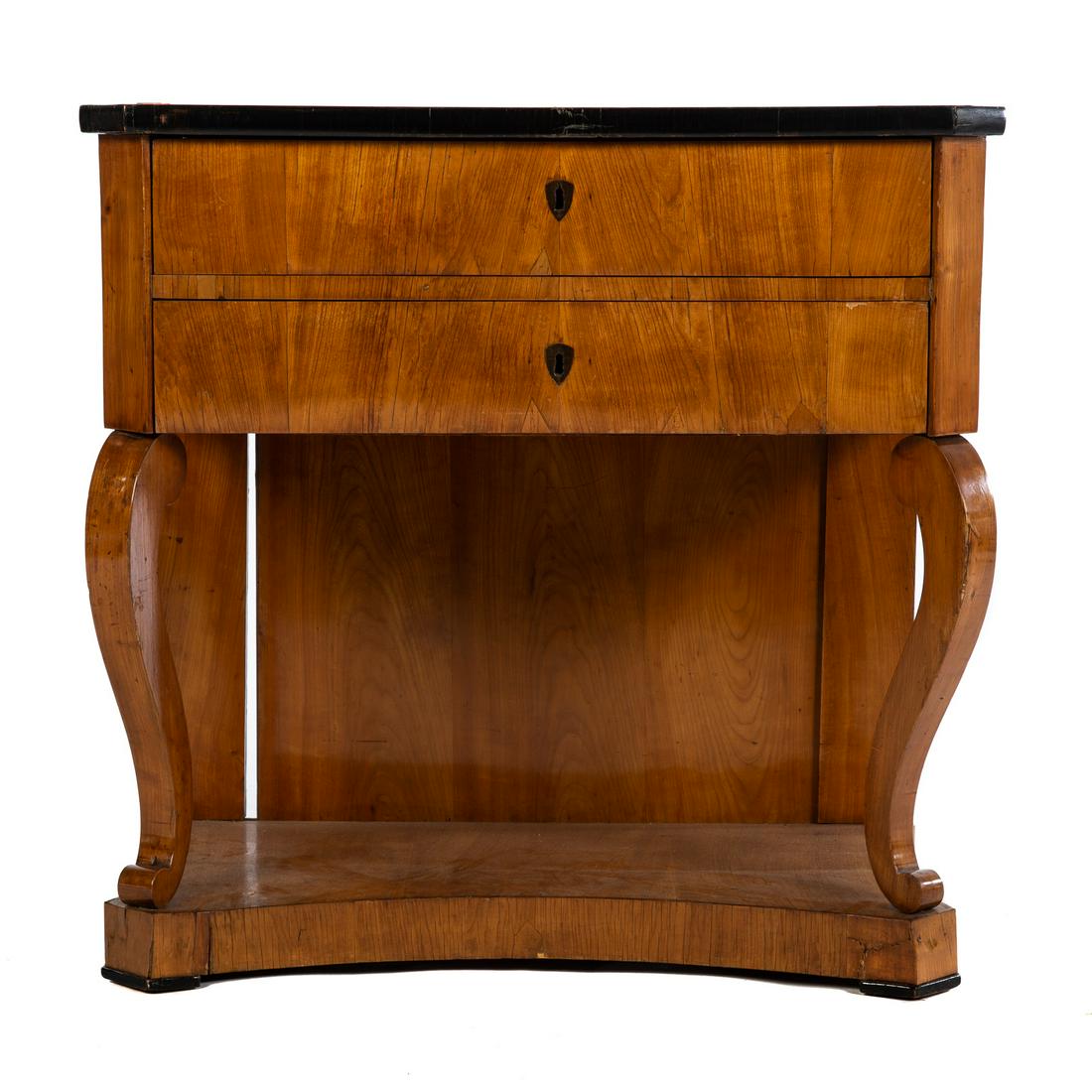 Biedermeier Pier Table: Circa 1860; shaped top with ebonized edge, over two drawers with pair of scroll supports on shaped base. 32 in. H., 33 in. W., 18.5 in. D. Estate of Linda McRae Noe Laine, heiress and philanthropist, 