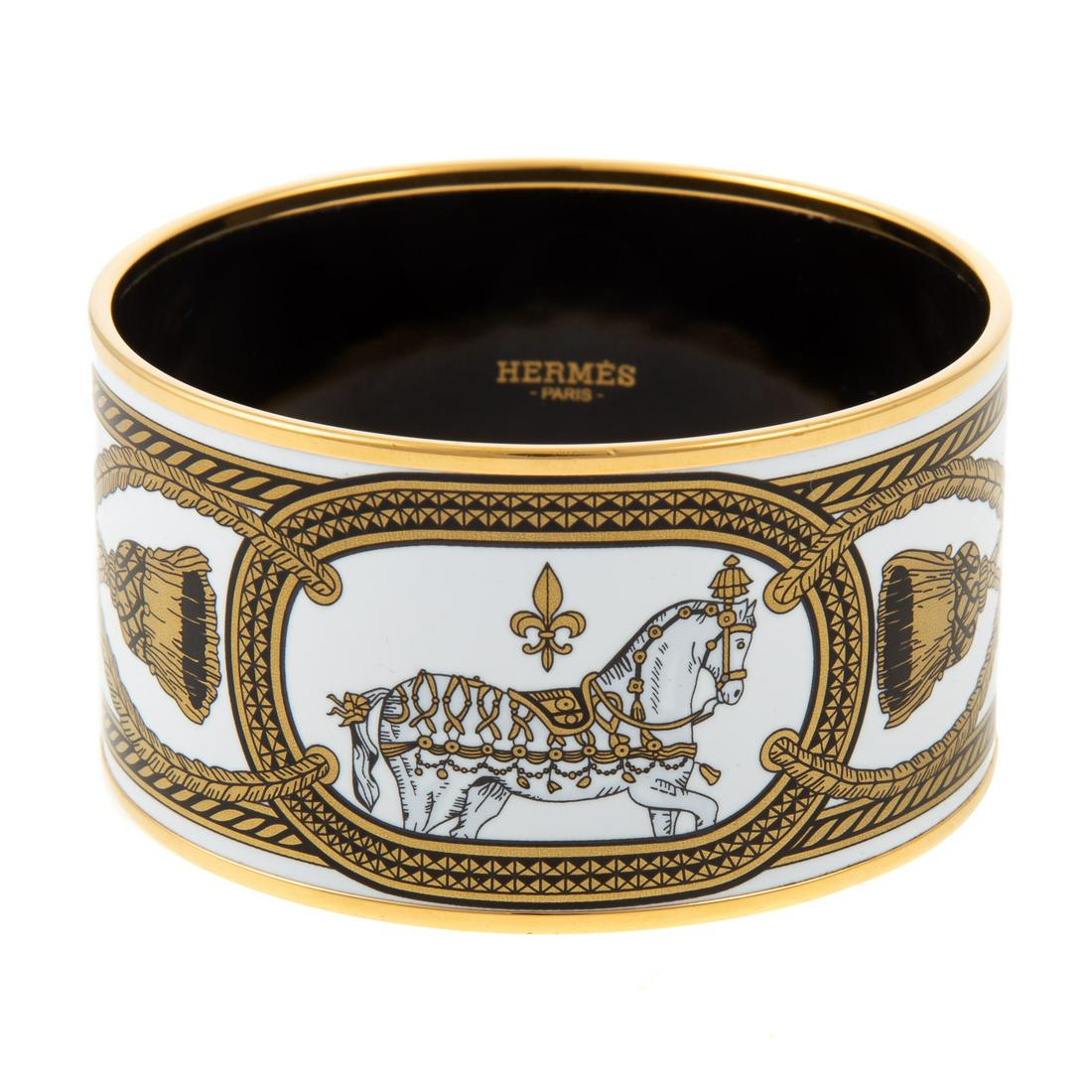 An Hermes XL Grand Apparat Platine GM Bangle: Black, white and gold Extra Wide Grand Apparat Platine GM Bangle featuring a horse and tassel motif with gold plated edges. Includes dust bag and box. Measuring: 2.75 in. diameter, 1.5 in. W
