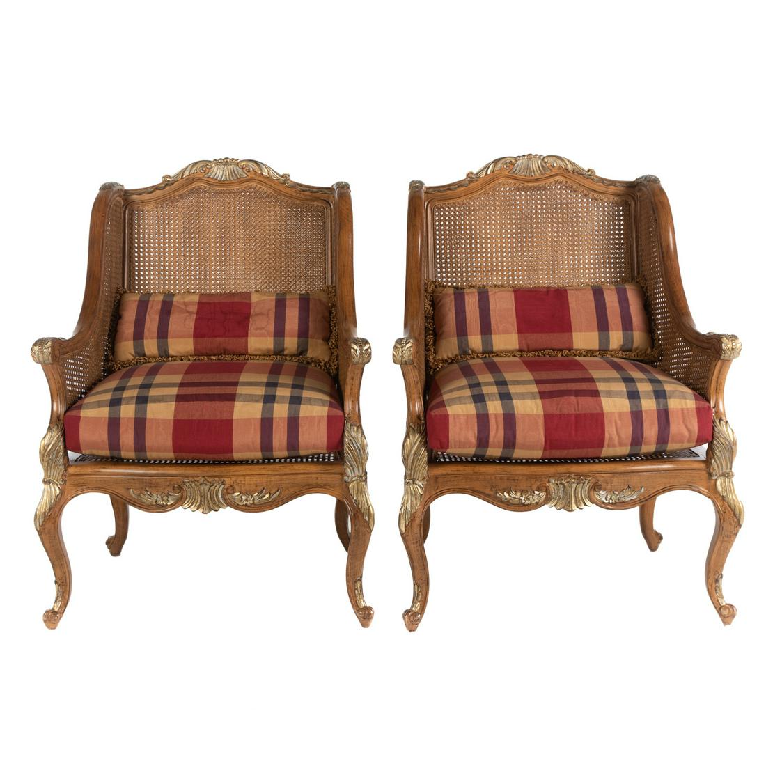 A Pair of Louis XV Style Cane Back Chairs: 20th century; elaborately carved with gilt highlighted areas, having removable upholstered cushions, 41 in. H., 31 in. W., 22 in. D.