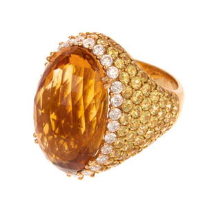 A Citrine, Diamond & Yellow Topaz Ring in 18K: 18K yellow gold ring featuring an oval checkerboard citrine measuring 14.9 x 23.2 mm, set with four split prongs, 28 round-cut diamonds weighing approx. 1.40 ctw with an average color grade of G-H,