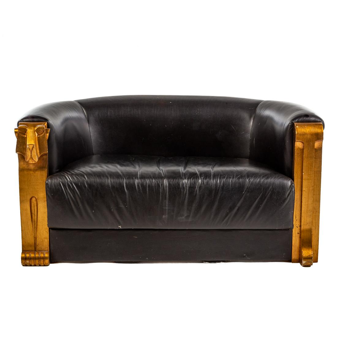 Art Deco Style Leather Loveseat: Mid 20th century; carved and giltwood lion face support and hind quarters with black leather upholstery, 30 in. H., 60 in. W., 30 in. D.