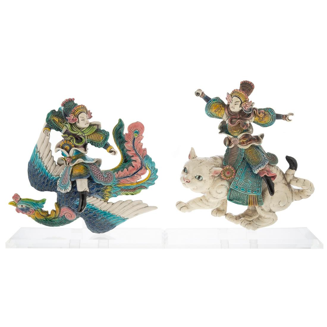 A Pair of Chinese Porcelain Wall Figures: 20th century; modeled as warriors riding phoenix and white cat, executed in polychrome enamel, phoenix is 12 in. H., cat is 13 in. H., each mounted on lucite stand.