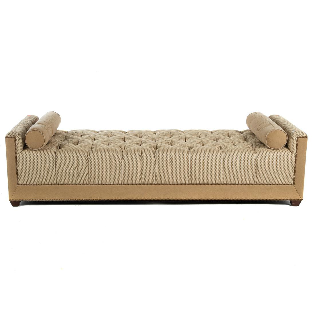 Baker Contemporary Upholstered Day Bed: 21st century; with modern tufted upholstery, having brass tack nail head trim, with two cylinder shaped accent pillows, 22 in. H., 84 in. L., 29 in. D.