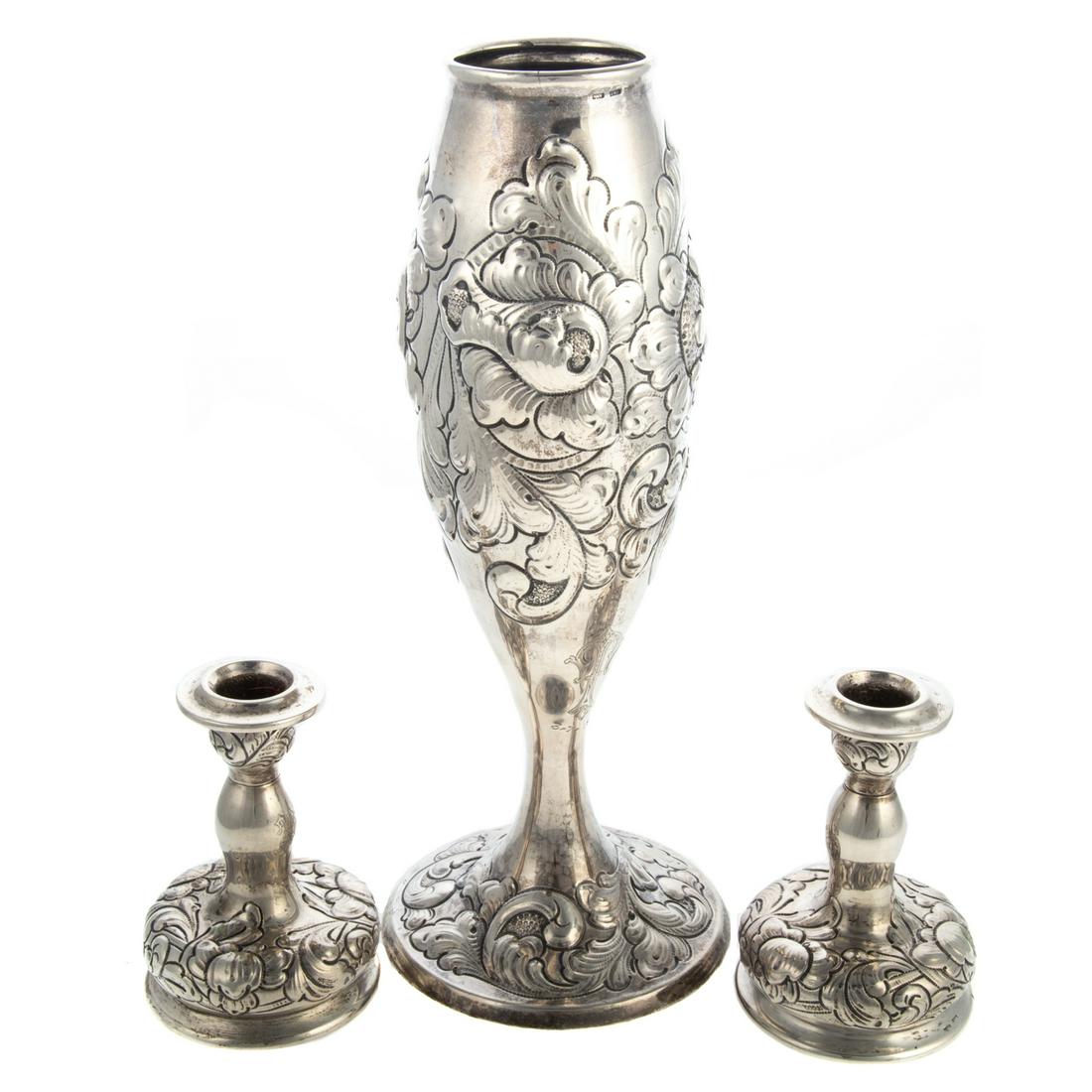 Norwegian Silver Garniture by N.M. Thune: Oslo, 830 silver standard, comprising a vase and a pair of candlesticks, each with lush foliate repousse decoration, monogrammed, the vase also inscribed "3-7-1922," 4 1/2 in. to 11 7/8 in. H, 23.35 o