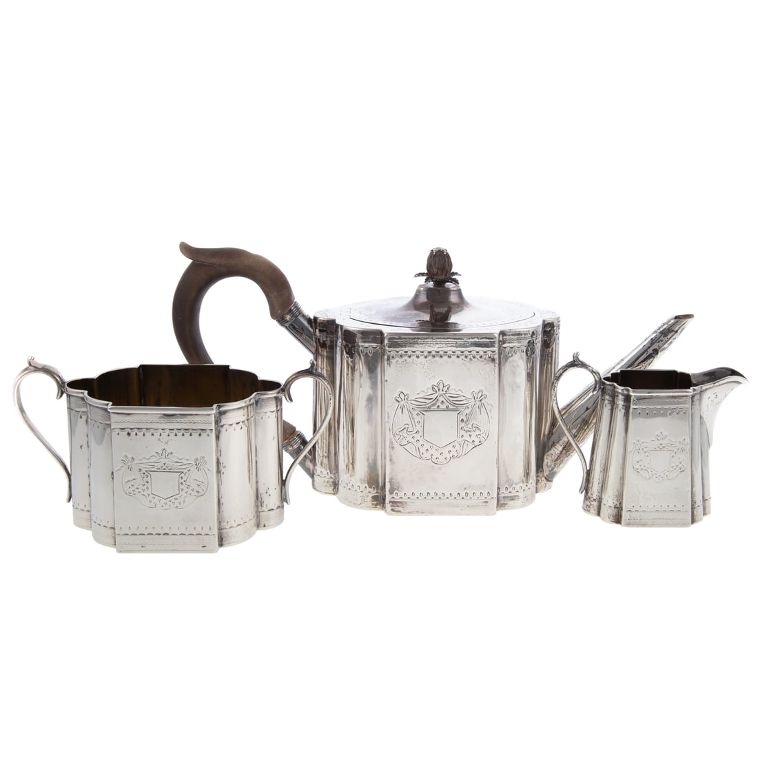 Scottish Victorian Silver Tea Set: J.R. & S., possibly for James Rettie & Son, Edinburgh, 1888. Three pieces including teapot, creamer, and sugar. Each shaped with rounded sides and corners, with chased band-work, each side with a chas