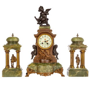 French Bronze & Onyx Clock Garniture: Circa 1860s; bronze case with green onyx base on bronze feet topped with winged fairy figure, and dial flanked by bronze putti, painted enamel dial, 21 in. H., 11 in. W., with a pair of classical styl