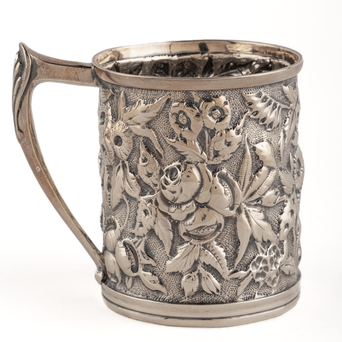 Welsh & Bros. Judaica Sterling Repousse Baby Cup: Baltimore, 1881-1910. Cylindrical, the body of floral and foliate repousse decoration, against a stippled ground, shell-capped handle, the underside inscribed "Moses W Rosenfeld. Born May 24th 1892. F