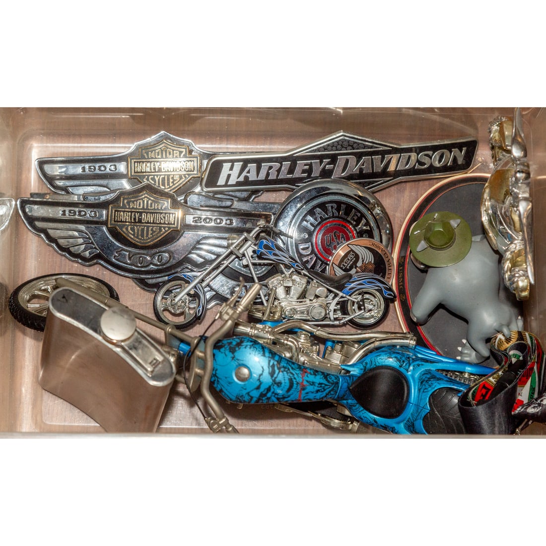 Collection of Harley Davidson Accessories: Includes two miniature bikes, emblems, a flask stamped with the phrase "LSD" on the front, and a Marine Corp. decorative item Provenance: From a lifelong collection of a Baltimore resident with a care
