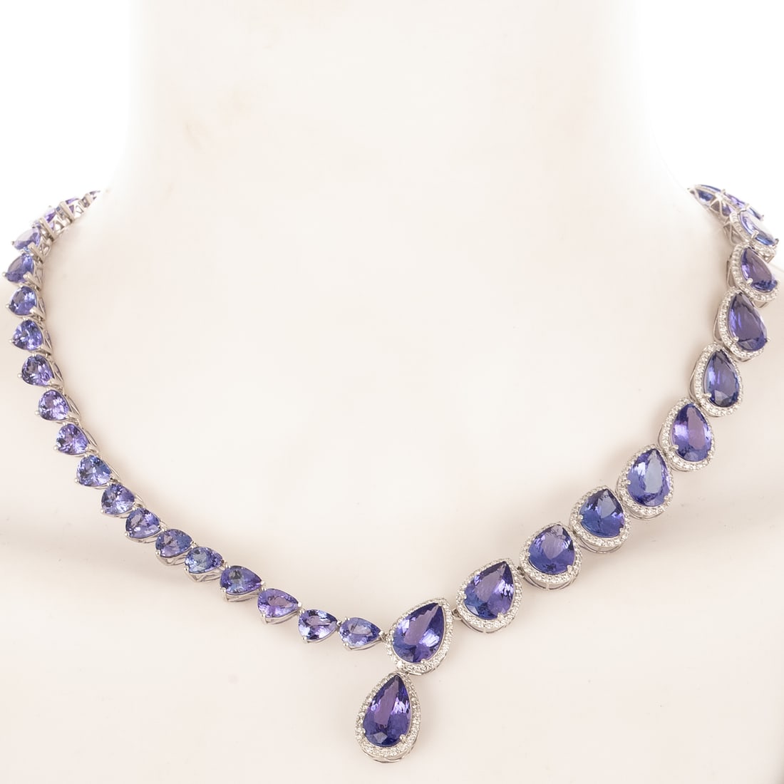 An Important Tanzanite & Diamond Necklace in 14K: 14K white gold necklace by Oscar Friedman featuring graduated pear shaped tanzanites with an intense bluish violet color, weighing approx. 90.00 ctw all prong set, one side of necklace tanzanites have