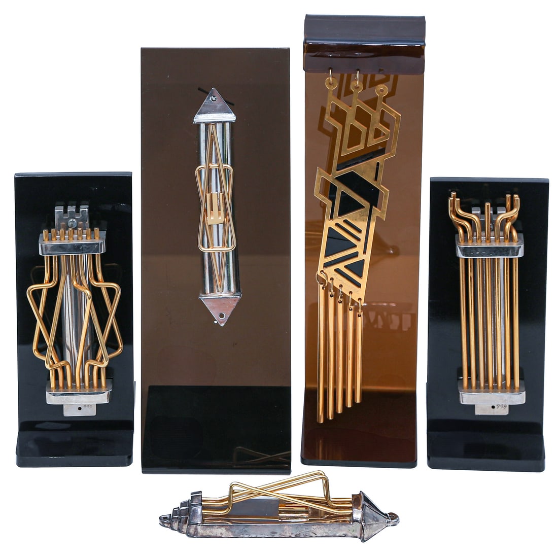 A Collection of 5 Kinetic Mezuzot by Naim Basson: (Israeli, born 1935) Hand crafted in silver-toned and gilt metal; two signed "Basson" and marked "999," most about 5 1/2 in. H, the tallest, 9 1/4 in. H. Four mounted on black plastic stands From an i