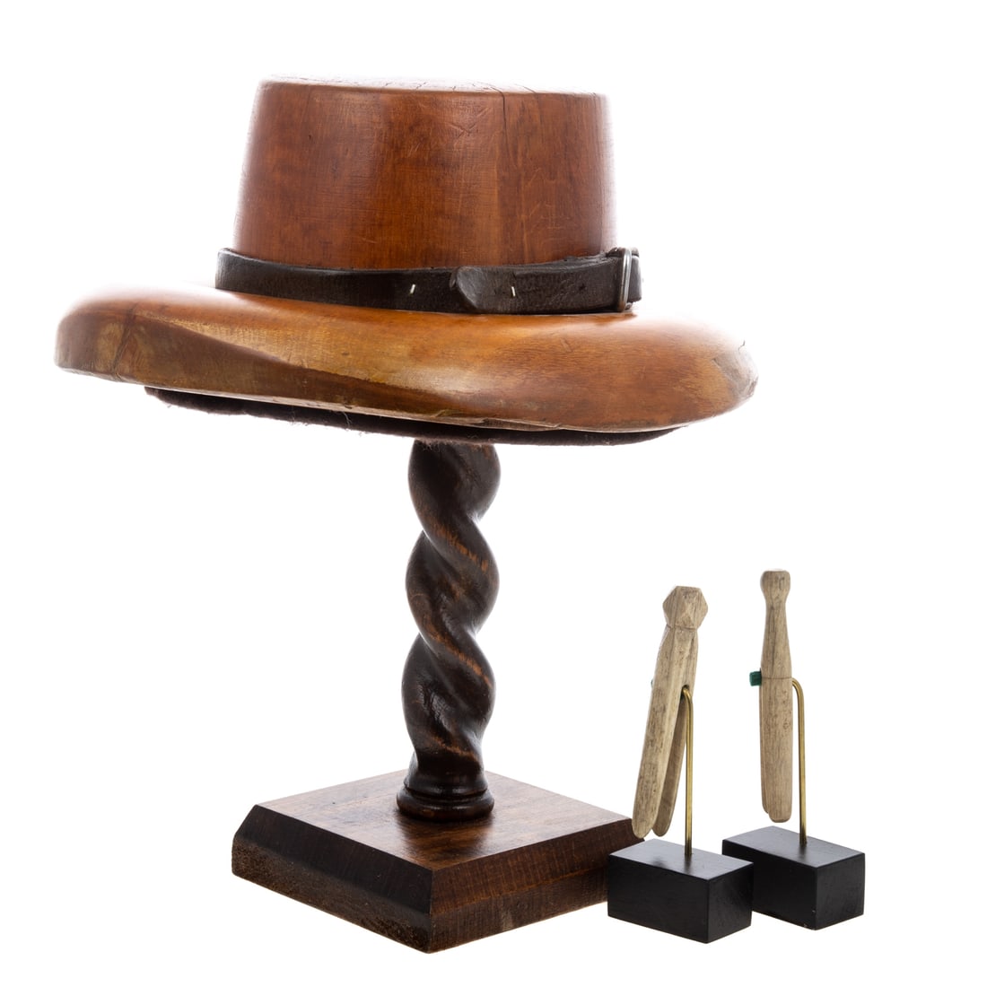 A Haberdasher Hat Model & Sailor-Made Whale Bone Clothespins: 19th and 20th centuries, a wooden haberdasher hat model, with leather belt on brim, and barley twist display stand, 15 in. H, 11 in. W, 12 3/4 in. L; and two sailor-made carved whale bone clothespins 