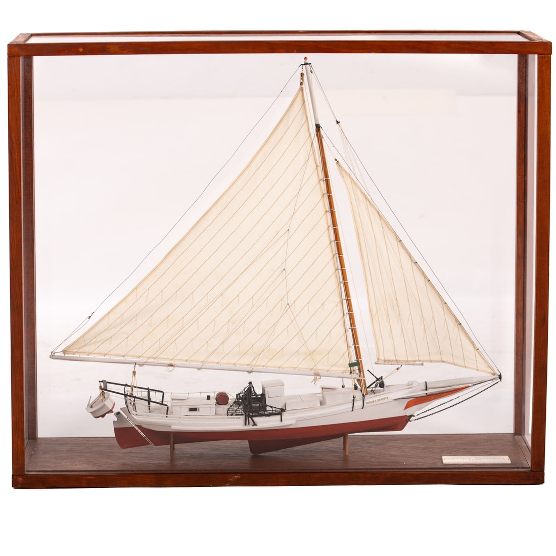 "Willie L. Bennett" Chesapeake Bay Skipjack Model: A cased Chesapeake Bay skipjack model of "Willie L. Bennett," a sailing oyster dredge boat, originally built in 1899 in Inverness, a town in Somerset County, Maryland. Includes information plaque abou
