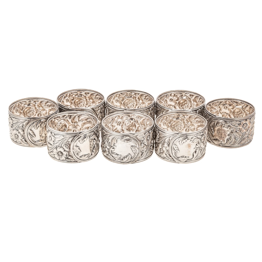 Eight S Kirk & Son Sterling Repousse Napkin Rings: Model# 28, decorated with crisp repousse flowers and foliage, against a stippled ground, with a leafy reserve, 1 7/8 in. Diam., 12.6 ozt.