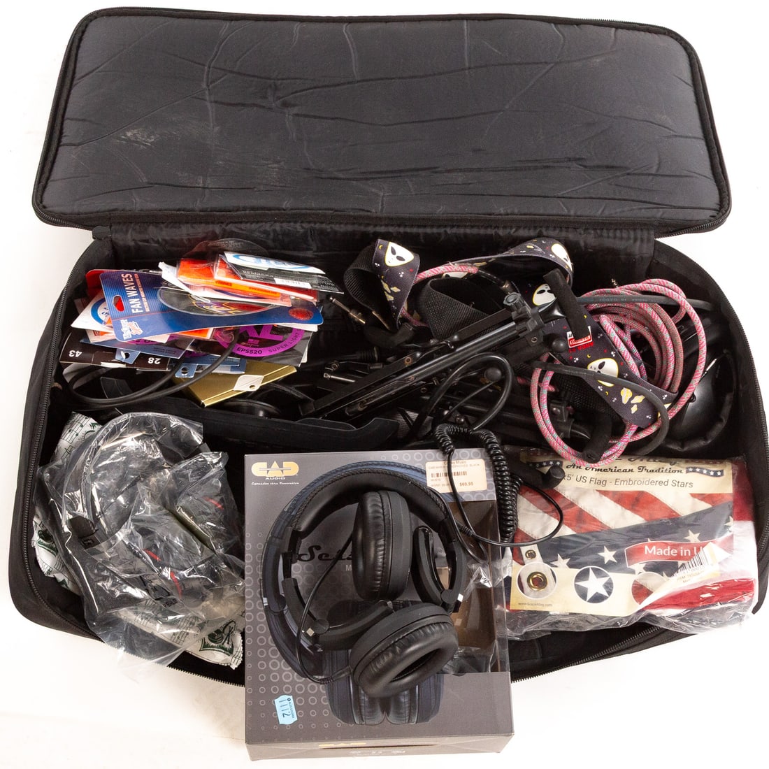 A Large Selection of Guitar Accessories & Cords: Including straps, strings, a power strip, electric guitar cables, CDs, American Flag, two sets of headphones, and a Sessions set of headphones with original box. Together with a pedal soft case From t