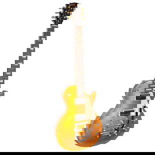 Les Paul Tribute Gold Top Electric Guitar: Gibson, Nashville, 1894; solid-body, mother of pearl inlaid fret board, with two pickups, a Bigsby tremolo, and gold finish; 2017 model, serial number 170094483. Includes a Seth Lover Humbucker set, a
