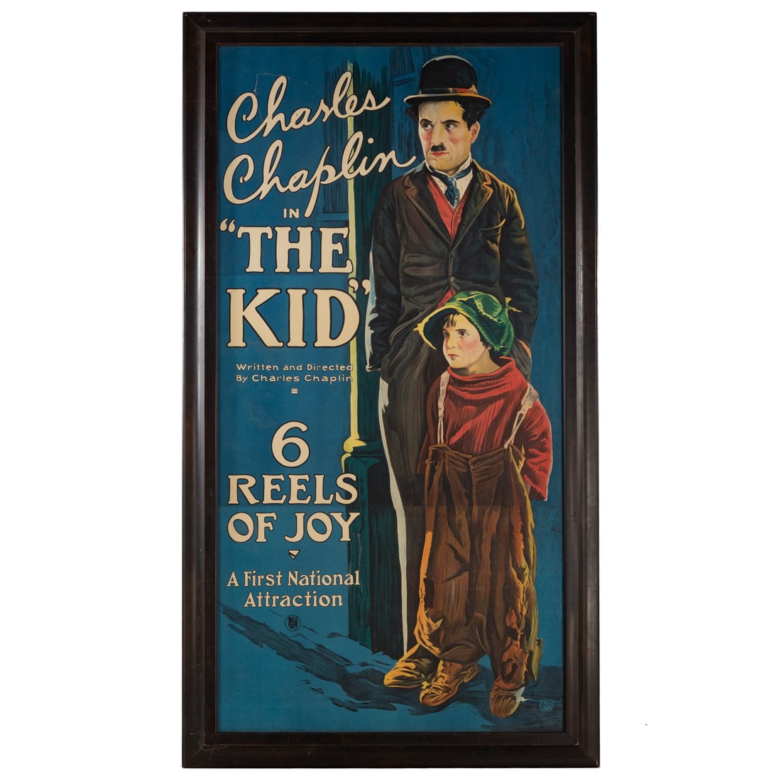 Charlie Chaplin, Framed Vintage Poster: Large color lithograph, featuring Charlie Chaplin in "The Kid" (dir. Charlie Chaplin, 1921), sight size: 79 1/2 x 40 1/2 in., framed size: 88 1/4 x 44 1/2 in. Provenance: From the Estate of a Private