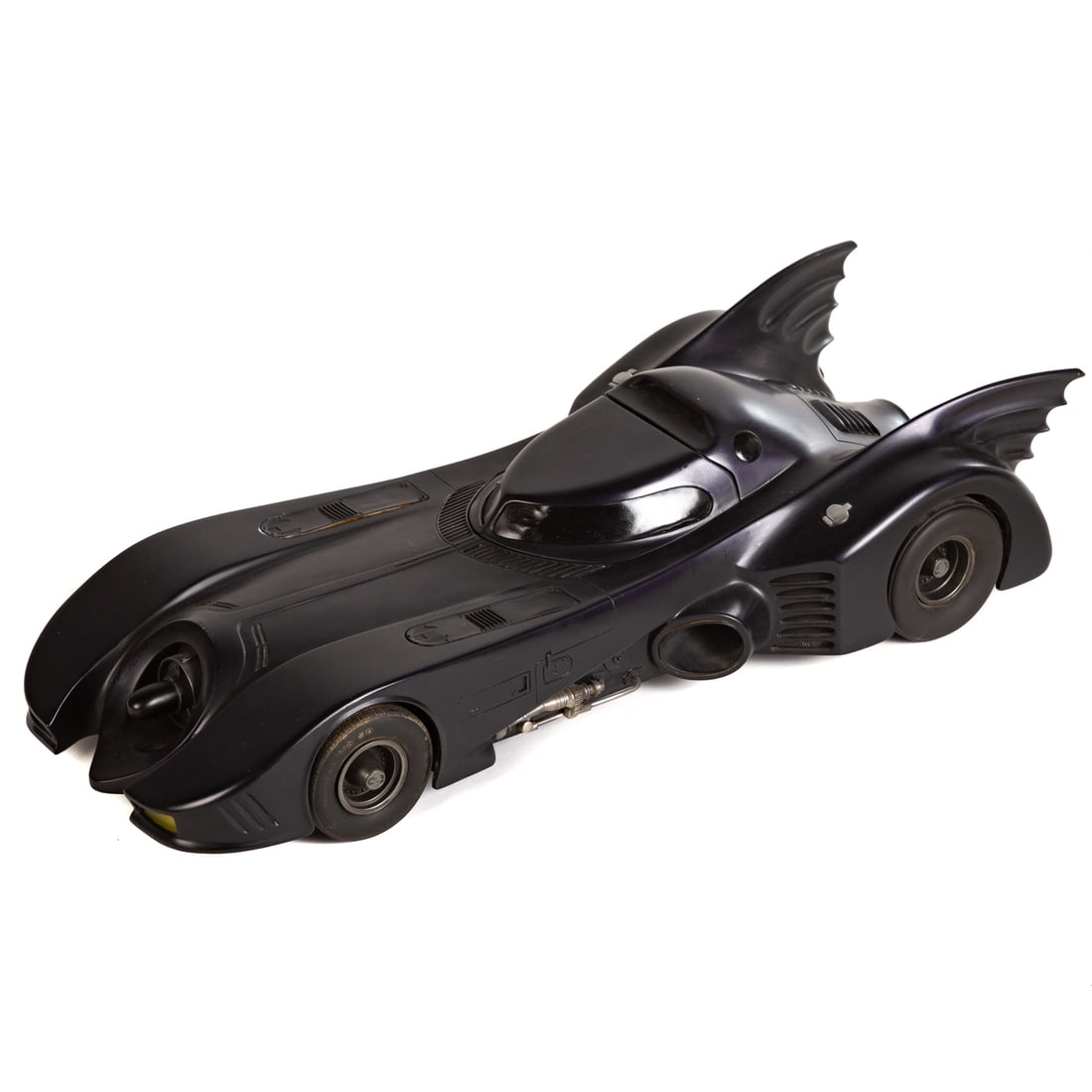 An Original Miniature Batmobile from Tim Burton's "Batman": An original miniature Batmobile serving as a production piece for "Batman" (dir. Tim Burton, 1989), approx. 6 1/4 in. H, 28 1/2 in. L, 12 in. D. Painted in a dark purple color scheme to assist in crea