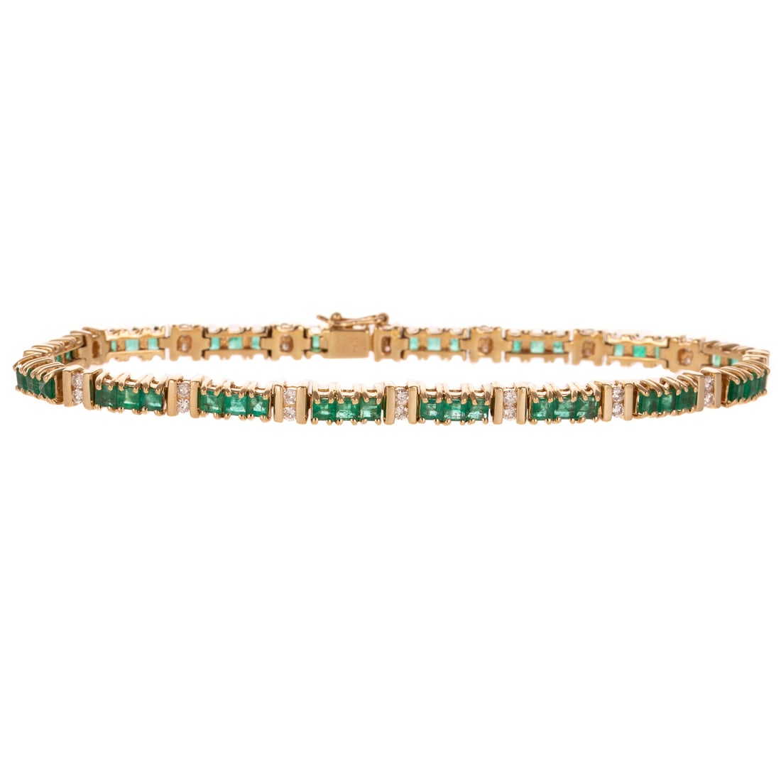 An Emerald & Diamond Line Bracelet in 14K: 14K yellow line bracelet featuring a line of prong set square shaped emeralds weighing approx. 4.00 ctw with a column of two channel set round diamonds in between each group of three emeralds, hidden